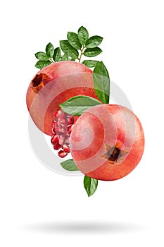 A ripe pomegranate with seeds and leaves flying in the air. Isolated object on a white background. Background with