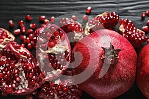 Ripe pomegranates on dark wooden background