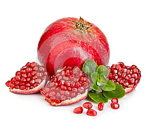 Ripe pomegranates with leaves close-up on a white background.