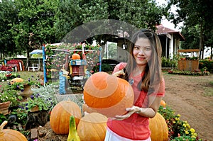 Ripe pumpkin lies with girl in a farm field