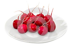 Ripe radish on a white plate on a white background. Close-up.