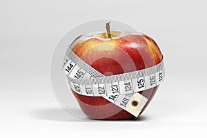 Ripe red apple with a measure tape