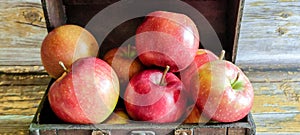 Ripe red apples in a wooden box. Apples in an old chest.