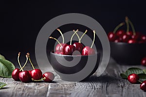 Ripe red cherries in a bowl and next to it