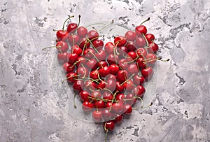 Ripe red cherries on gray background photo