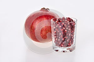 Ripe red garnet fruit. Pomegranate juice in a glass.