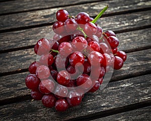 Ripe red grape. Pink bunch in a old rustic wooden table