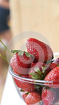 Ripe, red organic strawberries in  glass bowl. Summer fruits and berries. Selective focus