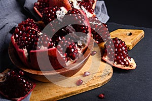 Ripe red pomegranate on wooden board and dark background