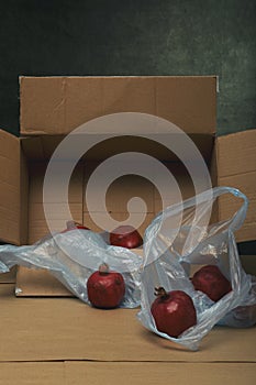 Ripe red pomegranates on the table in a cardboard box