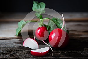 Ripe red radishes lying on wood background.