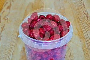 Ripe red raspberry berries close up  in a bucket. Natural vitamin food
