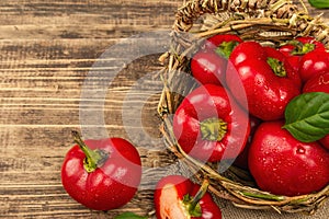 Ripe red round peppers in a handmade wicker basket