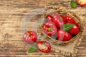 Ripe red round peppers in a handmade wicker basket