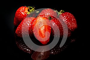 Ripe red strawberries on a black background. Fresh organic berry