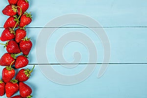 Ripe red strawberries on a blue wooden background