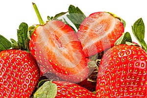 Ripe red strawberries with green leaves and two half of cutted strawberry on top isolated on white background close-up