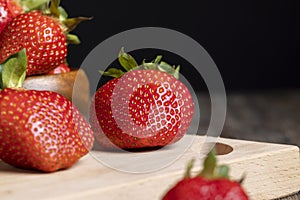 Ripe red strawberries lying on a wooden tray