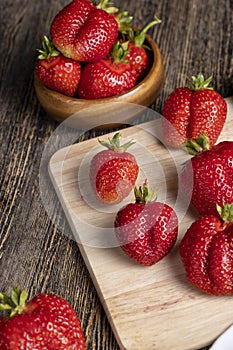 Ripe red strawberries lying on a wooden tray