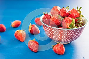 Ripe red strawberries on blue wooden table, Fresh strawberry, Strawberries in white bowl.