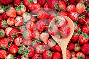 ripe red strawberry with wooden spoon background