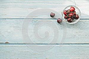 Ripe red sweet cherries on blue wooden background. Flat lay. Colorful diet and healthy food concept