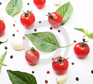 Ripe red tomatoes with basil, pepper and garlic isolated on white background. Top view.