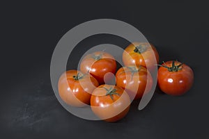 Ripe red tomatoes on black background