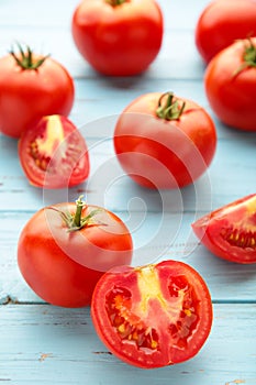 Ripe red tomatoes on a blue wooden background. Vertical foto