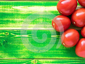 ripe red tomatoes on bright green wooden background table,