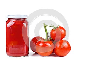 Ripe red tomatoes and glass jar with juice isolated on white background