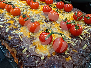 Ripe red vine tomatoes with stalks on an an onion tart
