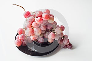 Ripe red wet grape with drops. Pink bunch with leaves