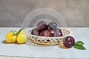 ripe red and yellow plums in a wicker basket