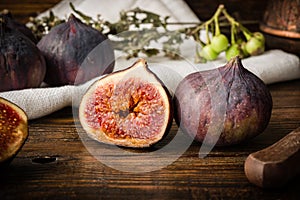 Ripe seasonal figs on wooden table with sliced one