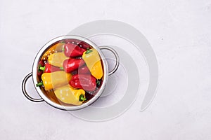 Ripe Small Red and Yellow Peppers in Bowl Light Gray Background Top View Copy Space Vegetable