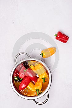 Ripe Small Red and Yellow Peppers in Bowl Light Gray Background Top View Vertical Copy Space Vegetable