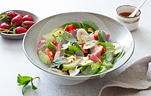 Ripe strawberries, apples, bananas, coconut and mixed salad leaves  healthy salad
