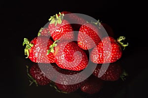 Ripe strawberries on a black background. Organic fruits