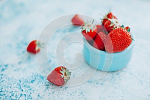 Ripe strawberries in a cup on a blue backgroung. Soft focus. Summer, vitamines