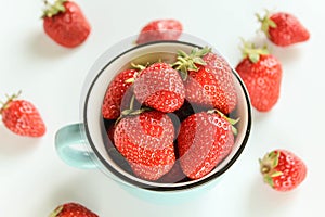 Ripe strawberries in a cup on a white background