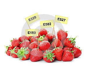 Ripe strawberries with E numbers on background. Harmful food additives