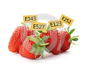 Ripe strawberries with E numbers on background. Harmful food additives