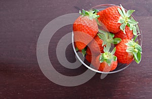 Ripe strawberries on glass over wooden background,copy space ,top view and on people