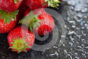 Ripe strawberries. Juicy ripe strawberries with drops of water on a wet dark background. Red berries. Copy space. Close-up.