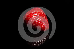 Ripe strawberry on a black background. Organic fruits