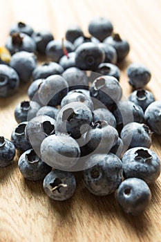 Ripe strewn blueberries on a wooden table, vertically