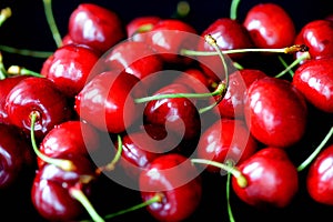 Ripe sweet cherry berries with water drops on a dark background