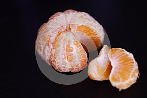 Ripe tangerine slices on a dark background in isolation