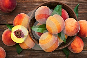 Ripe and tasty and juicy peaches lie on a plate on a wooden table. Large peaches on rustic wooden background, selective focus